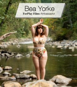 redhead BBW Bea Yorke, ForPlay Films feminist porn ambassador, poses in a river wearing floral pin-up lingerie