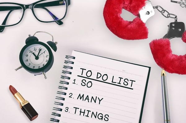 A To-do list (listing "So Many Things!")surrounded by fuzzy handcuffs, glasses, lipstick, and an alarm clock